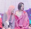 SANA is brushing JEONGYEON's thighs.