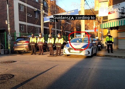 How a policewoman stands guard in front of Cho Doo-soon's house