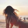 a bikini girl lying face down on the white sand